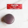 Un vasetto di vetro di olio di cocco Coccoon dall'alto e l'etichetta "parlante"